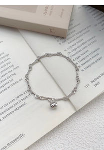 Macro shot of silver twisted chain bracelet featuring a delicate 3D pumpkin pendant detail
