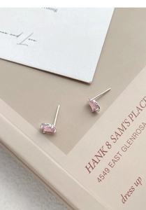 Macro detail of S999 silver stud earrings featuring rectangular pink zircon in claw setting