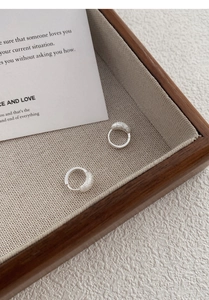 Détail de boucles d'oreilles créoles en argent S925 avec finitions sablée et polie miroir