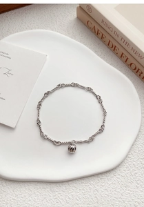 Detailed macro view of S999 sterling silver pumpkin charm on a twisted rope chain bracelet