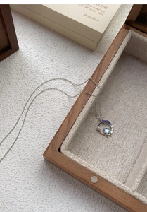 Gros plan du collier queue de poisson en argent S999 avec pierre de lune et émail