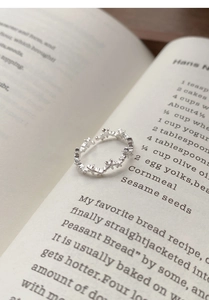 Detailed view of sterling silver star-shaped open ring placed on an open book