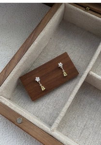 Detail of S925 silver star earrings with yellow waterdrop zircon in a wooden jewelry box