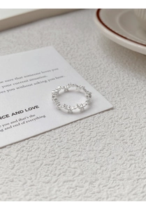 Detailed macro view of S925 sterling silver hollow star ring on a white textured background