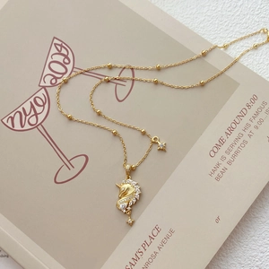 Collier élégant licorne dorée et étoile avec pendentif en zircone sur fond minimaliste