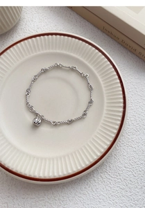 Detailed macro view of S999 sterling silver pumpkin charm bracelet with twisted oval links