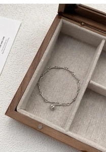 Close-up of S999 sterling silver pumpkin pendant bracelet on beige linen gift box