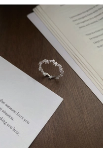 Close-up of S925 sterling silver star ring with micro-set zircons on rustic wood desk