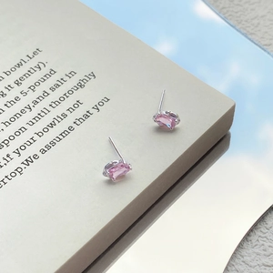 Pink zircon S999 silver stud earrings displayed on a book for a trendy minimalist style