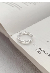 Detail of silver star ring band with multiple pentagram shapes on an open book