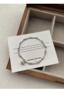 Macro detail of S999 sterling silver pumpkin bracelet with twisted rope chain and charm