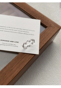 Detailed macro view of S925 sterling silver hollow star ring on a minimalist card
