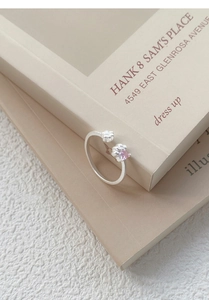 Détail de la bague patte de chat en argent S999 avec gemme coeur rose sur livre