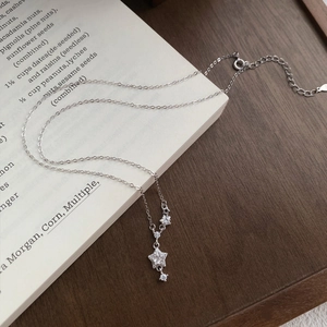 Elegant S999 silver star pendant necklace with sparkling cubic zirconia on a book