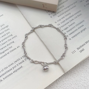 Elegant S999 silver pumpkin charm bracelet with twisted chain link on a book page