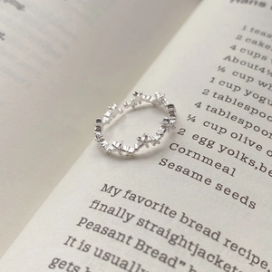 Minimalist S925 sterling silver open star ring placed on an open vintage book page