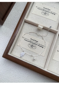 Gros plan du bracelet en argent S925 avec breloques de chat et clochette sur boîte