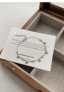 Détail macro du bracelet papillon en argent S925 avec zircons dans une boîte en bois