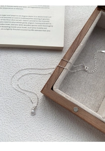 Vue détaillée du pendentif bourse de fortune en argent S999 avec chaîne O réglable sur boîte