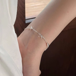 Elegant S999 silver anklet with starfish and bow pendants worn on ankle