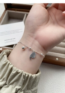 Détail du bracelet en argent S925 avec pendentifs chat et cloche porté au poignet