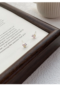 Détails macro des boucles d'oreilles en argent S999 avec zircons colorés sur un livre