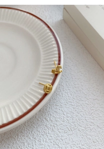 Detail of S925 silver matte gold stud earrings featuring horse and coin shapes