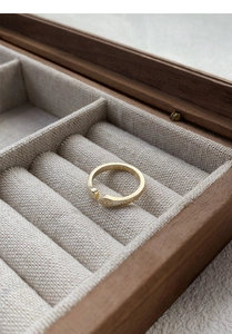 Detail of golden S999 silver cat claw open ring on soft linen padding inside a jewelry box