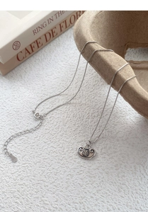 Macro shot of S925 sterling silver Ruyi Lock necklace with Fu character on white texture