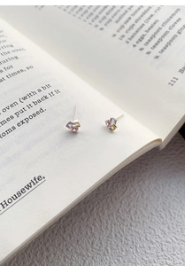 Gros plan de boucles d'oreilles en argent S999 avec zircons colorés sur un livre