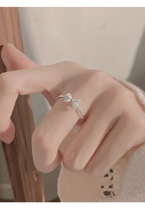 Detail of silver bow ring with shimmering cubic zirconia on woman's finger