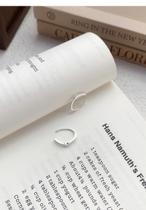 Detailed close-up of S925 sterling silver star ear cuffs with zircon stones on a book