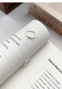Detail of S925 sterling silver hoop earrings with white zircon on a book background