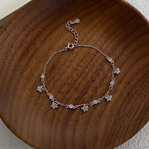Bracelet papillon élégant en argent S925 avec zircons scintillants sur un plateau bois