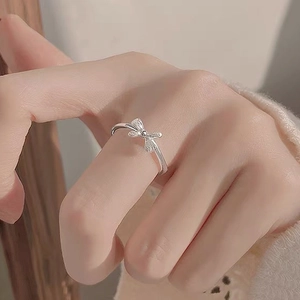 Minimalist S999 sterling silver bow ring with zircon stones on female hand