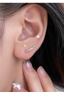 Detail view of S925 silver star stud earrings set with zircon stones on model ear