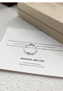 Macro detail of silver Mobius ring with zircon on a romantic poem gift card