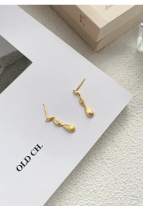Macro detail of matte gold water drop earrings featuring micro-set zircon accents