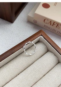 Macro shot of silver Mobius ring with zircon on a vintage display box cushion