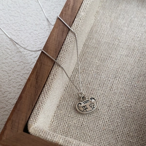S925 sterling silver necklace with vintage Ping An lock pendant on linen background
