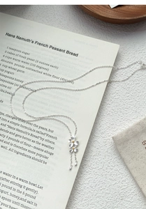 Dettaglio della collana gardenia in argento S999 con pistilli oro e piccoli ciondoli