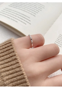 Close-up of S999 silver Mobius ring with zircon on woman's hand with cozy knit background
