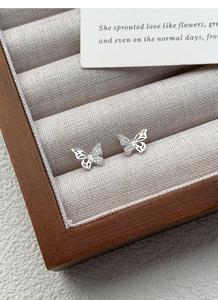Close-up of S999 sterling silver butterfly stud earrings with hollow wings and cubic zirconia