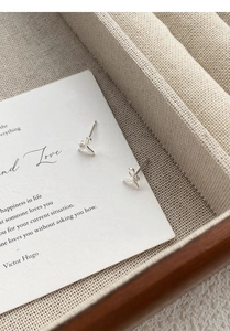 Detail of S999 sterling silver fishtail stud earrings with zircon in a jewelry box