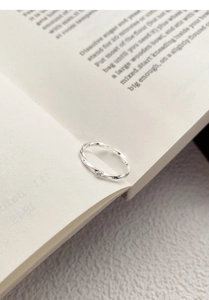 Close-up of S999 silver Mobius ring with zircon on an open book background