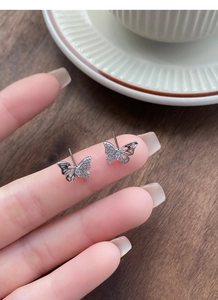 Macro detail of S999 sterling silver butterfly stud earrings with sparkling cubic zirconia