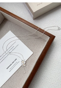 Dettaglio macro della collana in argento S999 con fiori di gardenia e nappe fini