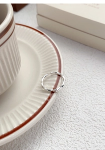 Detailed shot of S999 silver Mobius ring with zircon on vintage ceramic saucer