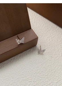 Macro shot of silver butterfly stud earrings with sparkling pavé cubic zirconia detail