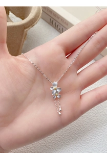 Dettaglio del ciondolo gardenia in argento S999 con finitura opaca e nappe a goccia